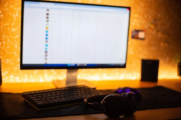 Wireless headphones near the computer in a dark room.