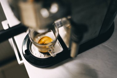 Kahve makinesi bir fincanı ekspreso ile dolduruyor. Otomatik kahve makinesinde şeffaf bardak. Kahvaltıda içecek..