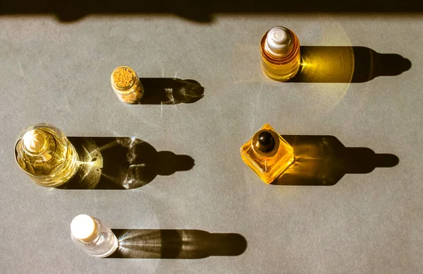 Gele Cosmetische Flessen Met Essentiële Olie Contrasterende Schaduwen Grijs Tafelblad — Stockfoto