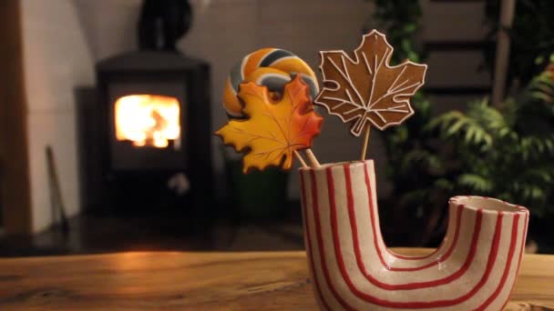 在壁炉里生着篝火的乡村住宅 现代装饰红色的白色花瓶与姜饼的形状秋天枫叶 舒适舒适的氛围 放松的地方 — 图库视频影像