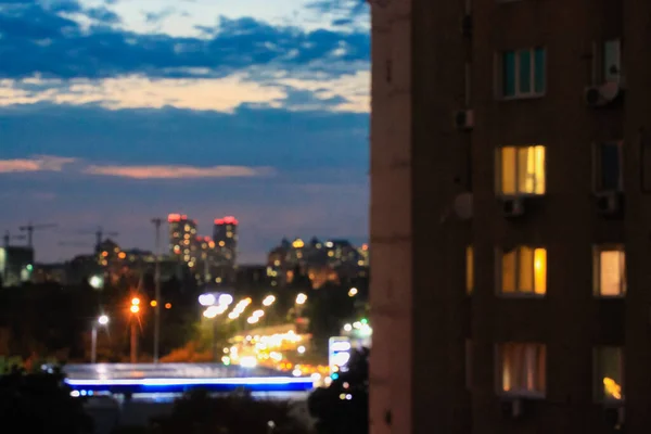 Желтый свет в окнах. Панорама большого города против темно-синего облачного неба ночью с видом на высотные здания на горизонте. Сумерки в городе. Размытое городское прошлое. Киев. — стоковое фото