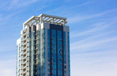 Mavi gökyüzü arka planında modern bir apartman dairesi. Hazır şantiyeye yatırım. Ofis, kiralık iş yeri. Büyük bir şehrin finans merkezinde gökdelen. Metin için yer.