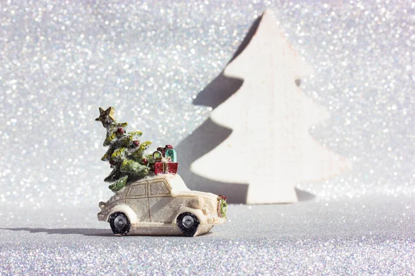 Toy car with Christmas tree on roof on silvered background. New Year 2022 winter — Fotografia de Stock
