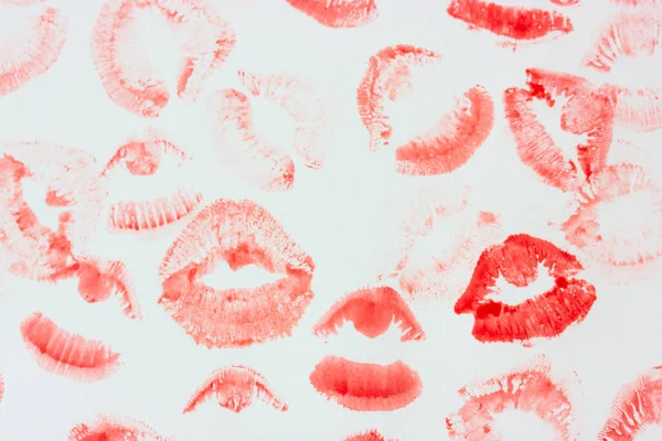 Set of sexy pink red female lip prints on white paper background top view. Kisses flatly. Lipstick prints, marks. Femininity, flirt, love concept. World Kissing Day. Valentines Day. Lovely backdrop.