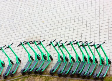 Kyiv, Ukrayna. 1 Mayıs 2021. Cıvata şirketi mobiletleri kaldırım manzaralı bir yere park edilmiş. Şehir sokaklarında halka açık kullanım için bir sıra yeşil elektrikli scooter. Modern şehir ulaşımı, hareketlilik 