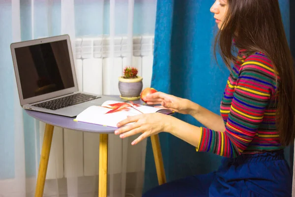 Κορίτσι με φορητό υπολογιστή σε ένα τραπέζι εργάζεται στο γραφείο στο σπίτι. Μαθήτρια που σπουδάζει εσωτερική — Φωτογραφία Αρχείου