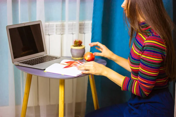 Όμορφη μελαχρινή κοπέλα με φορητό υπολογιστή σε ένα τραπέζι λειτουργεί μελέτες εξ αποστάσεως, γραφείο στο σπίτι — Φωτογραφία Αρχείου