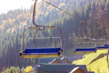 Bukovel, Ukrayna, 3 Ekim 2021. Boş kayak asansörleri kozalaklı ormanlarda. Kayakçıları kaldıracak halat, snowboardcuları dağ zirvesine insansız götürecek. Sonbahar mevsiminde dağlar kayak merkezi.