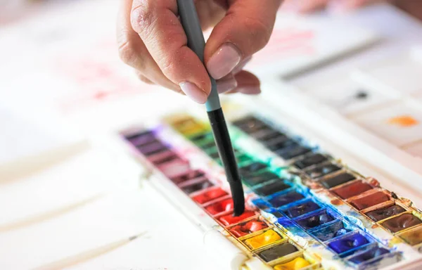 Artista Segurando Escova Molhando Com Aquarelas Paleta Vista Superior Mesa — Fotografia de Stock