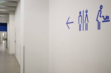 Kiev, Ukrayna. 7 Ocak 2022. Bir mağazaya imza atın, alışveriş merkezleri tuvaleti gösteriyor, tuvaletler bebekleri olan anneler için soyunma odası. Beyaz duvar mavi ok hareketi gösteriyor.