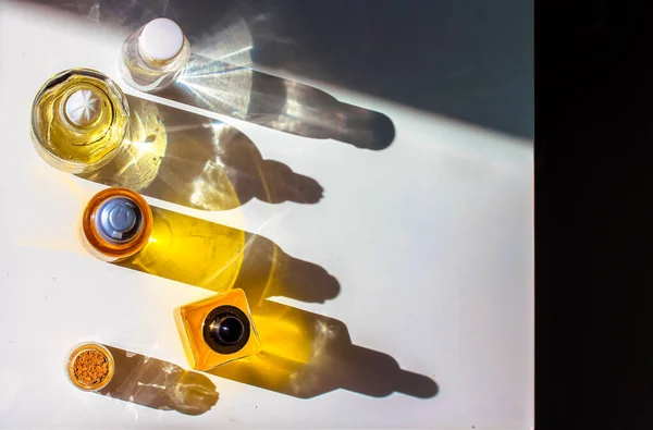 Gele Cosmetische Flessen Met Etherische Olie Wit Tafelblad Tegengestelde Schaduwen — Stockfoto