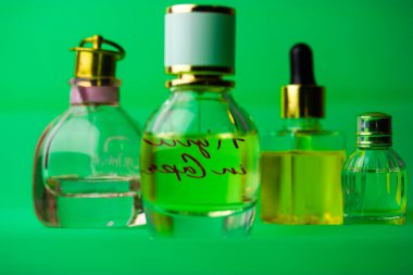 Kiev, Ukrayna. 1 Mayıs 2021. Cam şişe eau de tuvalet, parfümler, yeşil arka planda kokular. Şişelerdeki kozmetik yağı, kavanozlar. Güzellik bakımı. Parfüm için birkaç şişe. Aroma yağları.