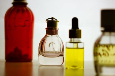Kiev, Ukrayna. 1 Mayıs 2021. Açık arkaplanda cam şişe eau de tuvalet parfümlerinin karşıt siluetleri. Kırmızı şişede krema losyonu. Tüpte merhem parlatıcı ruj, yağlı damlatıcı şişesi.