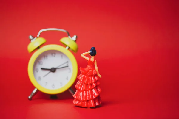 Speelgoedvrouw Rode Elegante Jurk Fixeren Haar Zoek Naar Gele Wekker — Stockfoto