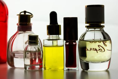 Kiev, Ukrayna. 1 Mayıs 2021. Açık arkaplanda cam şişe eau de tuvalet parfümlerinin karşıt siluetleri. Kırmızı şişede krema losyonu. Tüpte merhem parlatıcı ruj, yağlı damlatıcı şişesi.