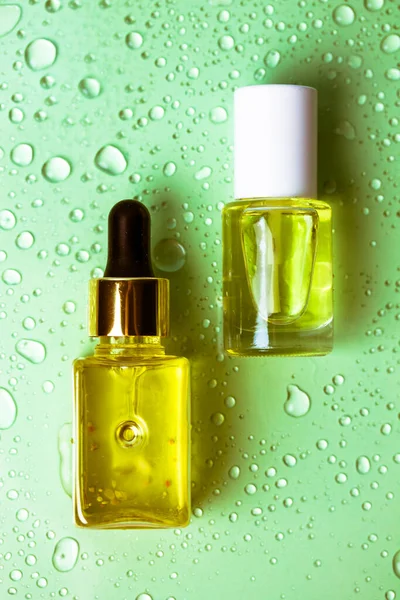 化粧品の包装 緑色の水に体のためのエッセンシャルオイルのガラスボトルのピペットドロッパーの背景をドロップします 化粧品だ 天然のエコマッサージオイル キューティクル保湿オイル — ストック写真