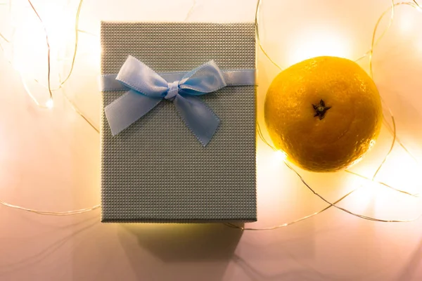 Modrá Dárková Krabice Lukem Leží Stole Hned Vedle Oranžové Mandarinky — Stock fotografie