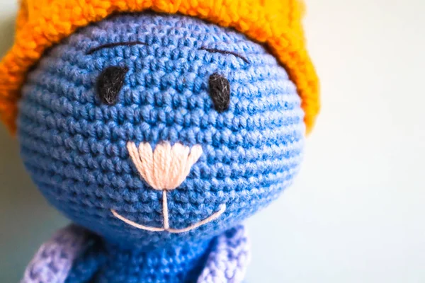 Blue crocheted knitted smiling toy cat in yellow hat with copy space. Amigurumi art. Fragment of childs vintage toy close-up. Creative handmade soft toy for babies, toddlers, kids. Childhood concept — Photo