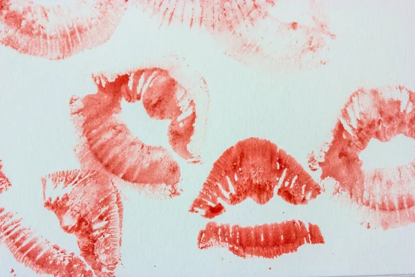 Set of sexy pink red female lip prints on white paper background top view. Kisses flatly. Lipstick prints, marks. Femininity, flirt, love concept. World Kissing Day. Valentine\'s Day. Lovely backdrop.