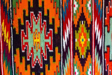 Etnik geometrik motifli doğal koyun yününden yapılmış parlak renkli yün halı. Hutsul halıları. El yapımı dokuma ürünü. Eşkenar dörtgenli parlak turuncu halı. Ukrayna geleneksel halısı