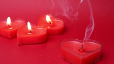 Mum söndü, duman yavaşça söndü, eriyip gitti. Kırmızı yanan kalp şeklindeki mumlar alevleri yaktı. Ateşin dilleri. Sevgililer Günü, tutku, aşk, romantik. 14 Şubat. Sönmüş mum mumu