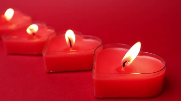 Candele rosse a forma di cuore ardente con fiamme ardenti. Lingue di fuoco su sfondo rosso. San Valentino, passione, amore, sentimenti, atmosfera romantica. Carta da parati monocromatica. Arredamento per il 14 febbraio. — Video Stock