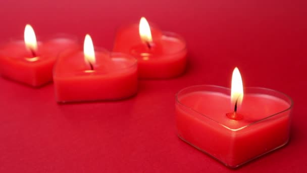 불타는 듯 한 심장 모양의 촛불이 타오르고 있습니다. 빨간 배경에 불을 뿜는 혀. 발렌틴 데이, 열정, 사랑, 감정, 로맨틱 한 기분의 개념. 모노크롬 벽지. 2 월 14 일을위한 장식. — 비디오