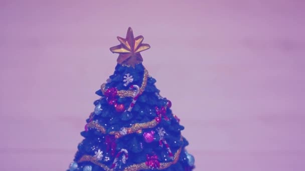 Christmas tree spinning around. Merry go round music box. Beautifully decorated ornate Christmas tree with golden star, balls. Happy New Year 2022 concept. I wish you a merry Christmas. Lilac toning. — Stock Video