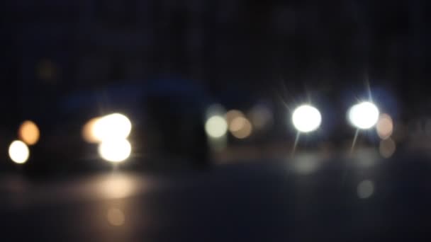 Luces borrosas de los coches con faros en movimiento lento en la carretera por la noche. Los automóviles están conduciendo por la noche con luces intermitentes. Desenfocado noche en la gran ciudad, calle de la ciudad vídeo abstracto. Transportes — Vídeo de stock