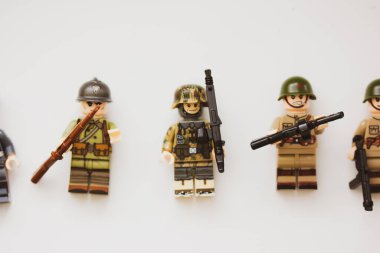 Kyiv, Ukrayna. 9 Mart 2022. İkinci Dünya Savaşı 'nın oyuncak LEGO askerleri üniformalı, makineli tüfekli, silahlı. Beyaz arka plan manzaralı birlikler. Savaş askeri tatbikatları. Silahlı kuvvetlerin oluşumları.