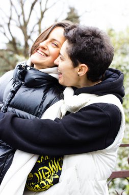 Birbirine aşık iki güzel kız dışarıda eğleniyor. Gülümseyen genç ve güzel kadınlar birlikte mutlular. Bir çift lezbiyen, LGBT, eşcinsel çift. Gurur ayı. Gerçekten olumlu duygular. Dikey fotoğrafçılık.