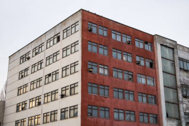 Terk edilmiş beyaz bir binanın ön cephesi. Evin köşesi, iş yeri, fabrika, reklam, perakende, ofis alanı. Sovyetler Birliği sonrası bir mimari. Binaların düz geometrik şekilleri