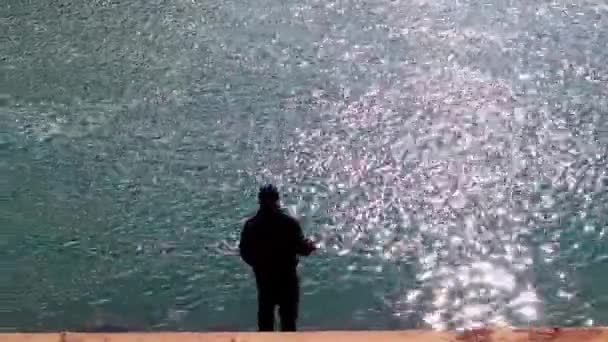 Silueta Pescador Con Una Caña Pescar Pescando Una Orilla Lago — Vídeo de stock