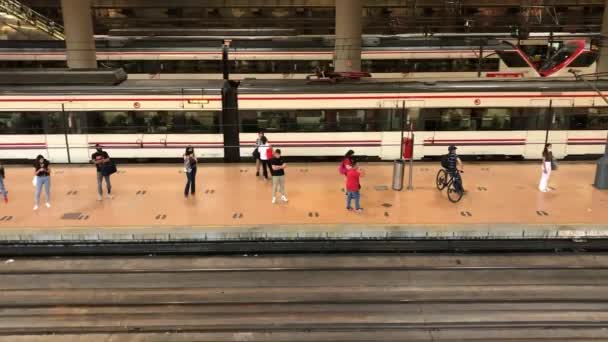 西班牙马德里 2022年5月7日阿托查火车站人们站在月台上等待高速列车的出游 从轨道上方俯瞰 有轨电车 Renfe国家铁路网 — 图库视频影像