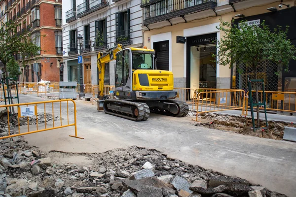 スペインのマドリード 2022年6月7日 道路工事だ 街の中心部に建設中の通り 掘削機は建設現場で働き 土壌を掘ります 黄色のブルドーザーは 街の通りからアスファルトを削除 — ストック写真