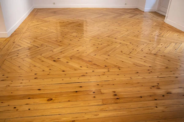 Herringbone Parquet. Natural materials wood flooring installation. Veneered parquet, parquet board, skirting. Flooring in the classical interior. Seamless brown grunge floor texture. Flooring at home.