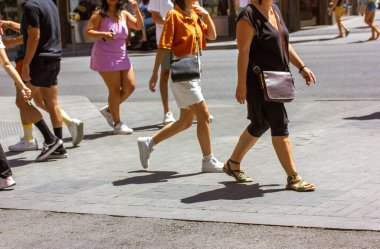 Güneşli bir yaz gününde bir şehir yolundan geçen yayalar. Şehir sokağı. Sokaktaki bir grup farklı insanın hareketi. Zebra şehir merkezinde. Meşgul metropol modern yaşam tarzı. İş çıkışı. 