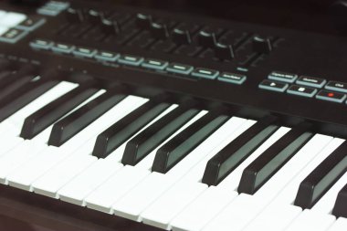 Siyah tuşlu piyano, kayıt stüdyosunda sentezleyici. Müzik yapımcısı için profesyonel Hi-Fi ses ekipmanı. Müzik yapmak için klavye. Bir müzik aleti fotoğrafçılığı. Elektronik müzik.