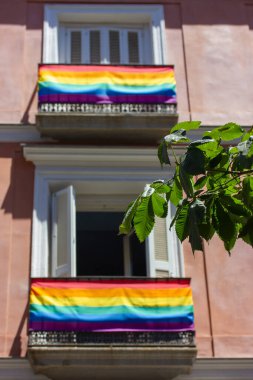 Madrid, İspanya. 7 Haziran 2022. Avrupa sokaklarında bir apartmanın balkonlarında parlak gökkuşağı LGBT bayrakları. Gurur Ayı. Uluslararası Homofobi Karşıtı Transfobi Günü, IDAHOT. Gey Özgürlük.