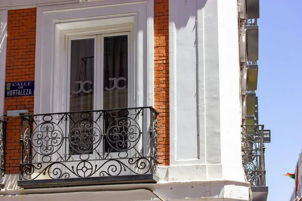 西班牙马德里 2022年7月1日 Calle Hortaleza一座红色旧住宅的拐角处 古色古香的建筑立面 有漂亮舒适的阳台栏杆和栏杆 城市建筑 — 图库照片