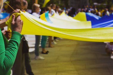 Rusya 'nın savaşında Ukraynalıları desteklemek için toplanan vatansever bir kalabalık. İnsanlar, Ukrayna 'nın bağımsızlığının bir sembolü olan büyük sarı bir Ukrayna bayrağı tutuyorlar. Çatışmada Ukrayna 'yı kurtar. NATO zirvesi.