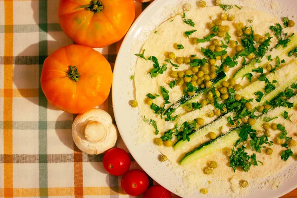 Lavash tortilla wrapped with chopped vegetables, orange tomatoes, mushrooms, cheese on a white plate top view. Cooking preparing healthy food by recipe. Nutrition at home rustic kitchen table flatly.