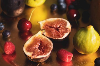 Taze sulu incirler, egzotik tropikal mevsimlik meyve ve meyvelerin arasında tabağa konur. Kırmızı kiraz, yabanmersini, ahududu. Meyvelerle dolu güzel bir hayat. Sağlıklı beslenme, vitaminler..