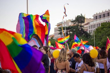 Madrid, Spain. July 3, 2022 A crowd of different young people, youth have fun dancing outside at a Pride month on gay parade 2022. LGBT symbols, rainbow flags. Summer Festival joy. Relax outdoors.