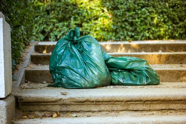 Green Plastic Trash Bags Lying Steps Park Green Natural Blurred — Foto Stock