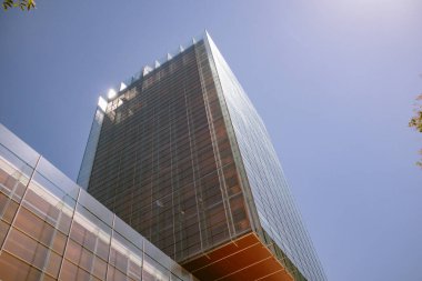 Madrid, Spain. July 1, 2022 A modern tall building with a glass facade against a blue sky. The office building of the Perez-Llorca company in a urban city center. Architect Rafael de La-Hoz Castanys.