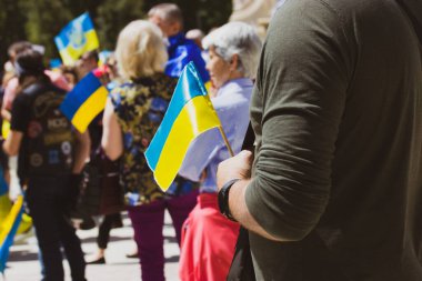 Madrid, İspanya. 7 Mayıs 2022. Ukraynalılar, Rusya 'nın Ukrayna' yı işgalini protesto eden bir mitingde sarı ve mavi Ukrayna bayrakları sallıyorlardı. Putin 'in savaşını protesto eden vatanseverler ve eylemciler. Dikey fotoğraf.