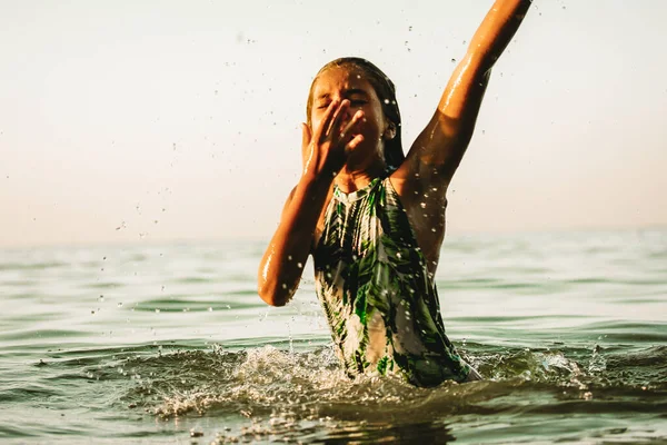 Child drowning in water holding hand above a surface of green water, going deep. Accident in a river, sea, ocean. Dangerous situation on summer coast. Help me concept. Teenage girl drowns. Film filter