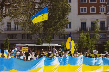 Madrid, Spain. July 1, 2022 A crowd of patriots at rally in support of Ukrainians in Russia's war. Huge yellow blue Ukrainian flag, a symbol of Ukraine's independence. Save Ukraine in war. Peace rally