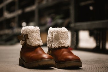 Koyun postu kürklü eski deri çizmeler, çocuklar için kışın izole edilmiş ayakkabılar. Retro ayakkabılar. Bir ikinci el mağazasında yün süslemeli çizme ya da evsizler ve mülteciler için insani yardım mağazası.